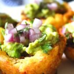 a cup of beautiful stuffed tostones. A baskeck made of platain stuffed with ground beef, guacamole and pickled onions