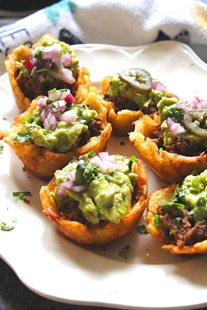 stuffed tostones with guacamole and ground beef. Plantain cups